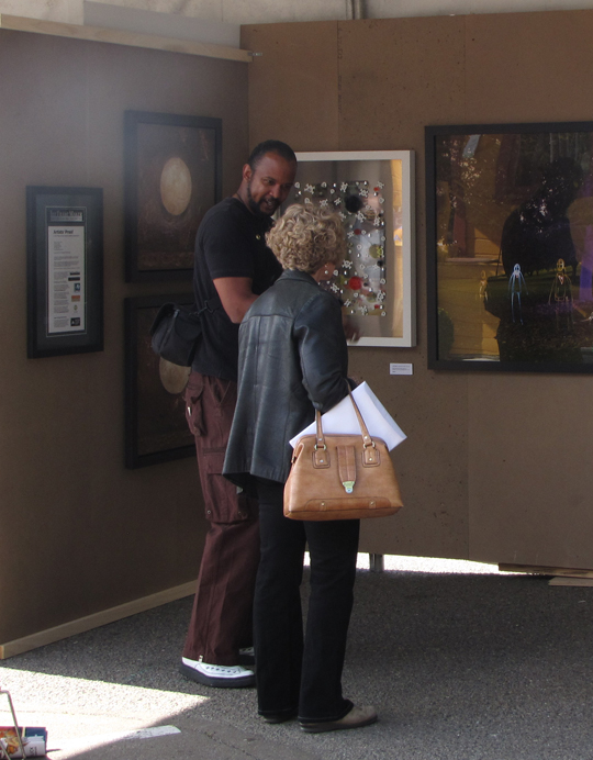 Gary Welsh talking to ArtWalk guest at The Frame Maker booth